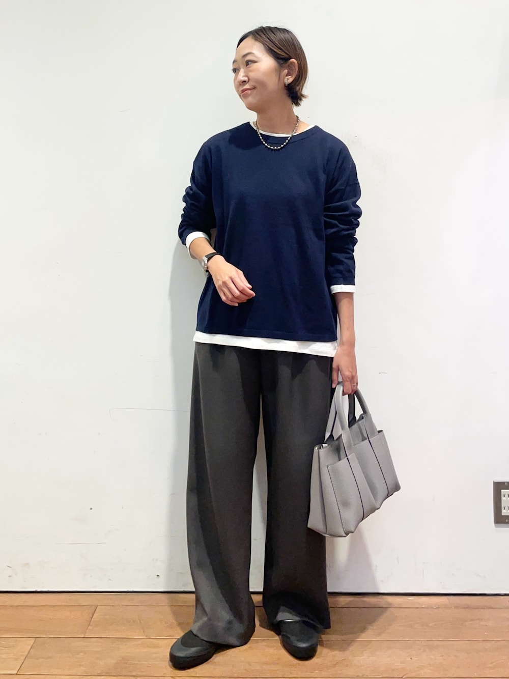 ブルー系のニット/セーター、グレー系のトートバッグ、ブラック系のバレエシューズを着用したレディースの秋コーディネートの1枚目の写真