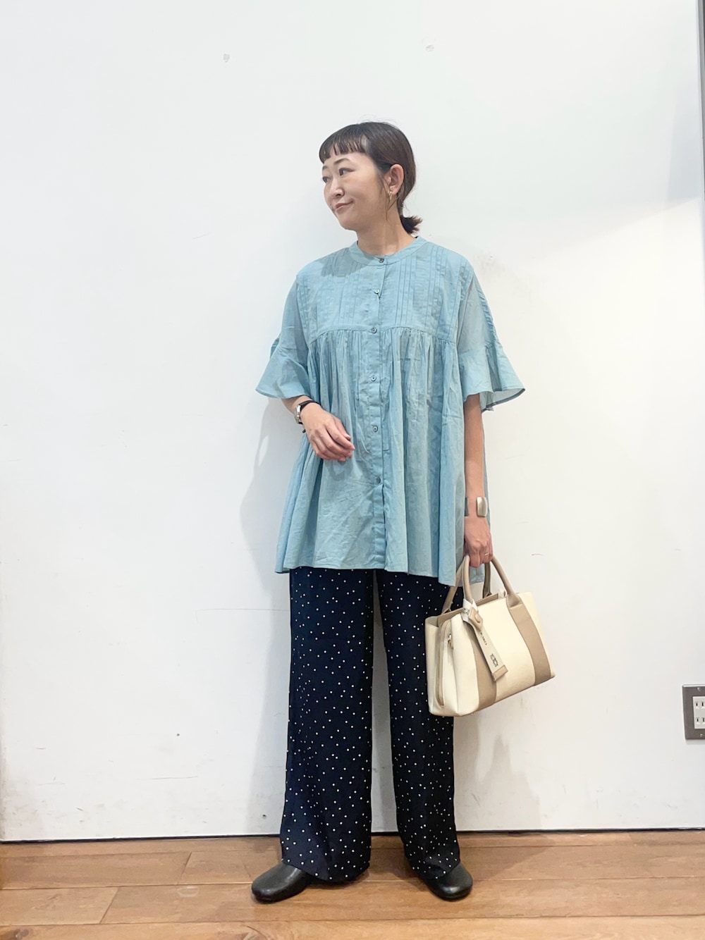 ブルー系のシャツ/ブラウス、ブルー系のその他パンツ、ホワイト系のハンドバッグを着用したレディースの夏コーディネートの1枚目の写真