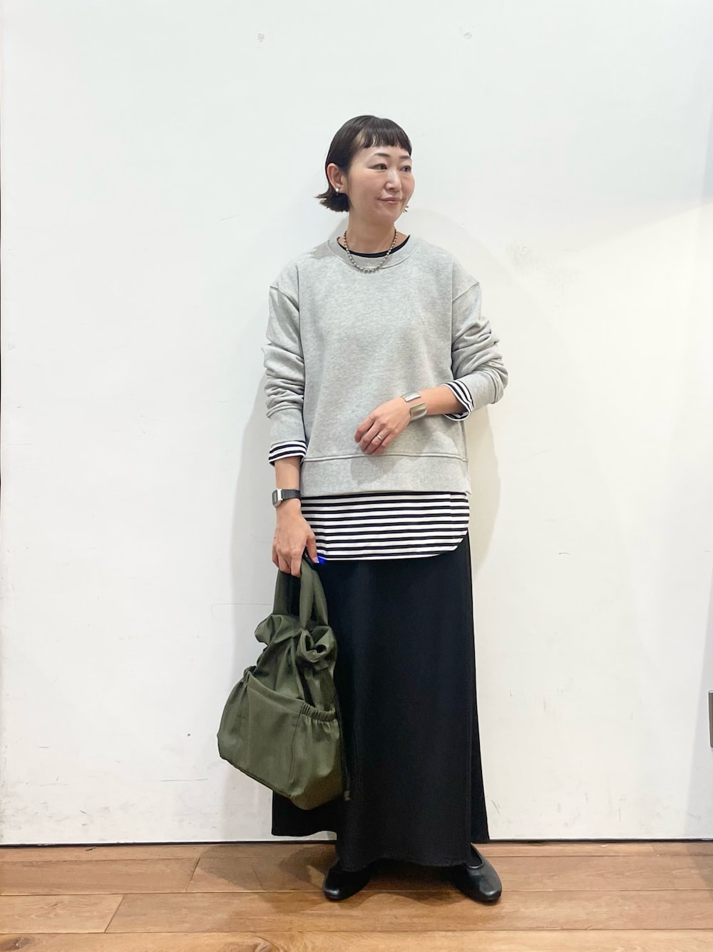 グレー系のスウェット、ホワイト系のTシャツ/カットソー、ブラック系のスリッポンを着用したレディースの秋コーディネートの1枚目の写真