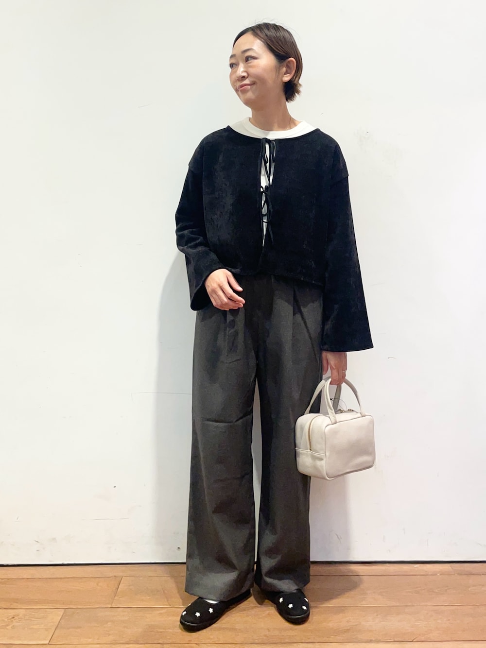 ホワイト系のTシャツ/カットソー、ブラック系のスニーカー、グレー系のボストンバッグを着用したレディースの秋コーディネートの1枚目の写真