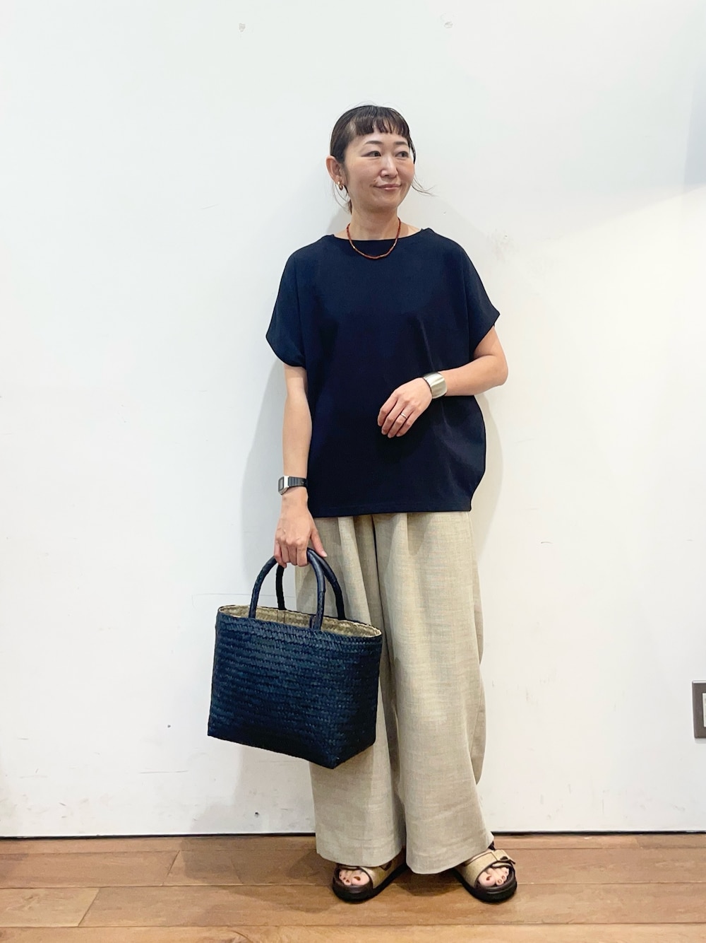 ブルー系のTシャツ/カットソー、ベージュ系のサンダル、ブルー系のトートバッグを着用したレディースの夏コーディネートの1枚目の写真