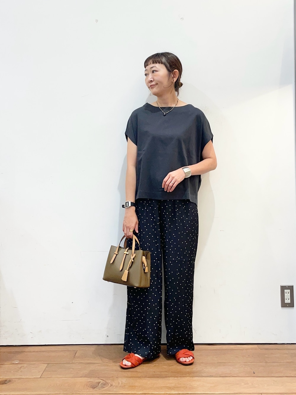 ブラウン系のハンドバッグ、レッド系のサンダル、ブルー系のその他パンツを着用したレディースの夏コーディネートの1枚目の写真