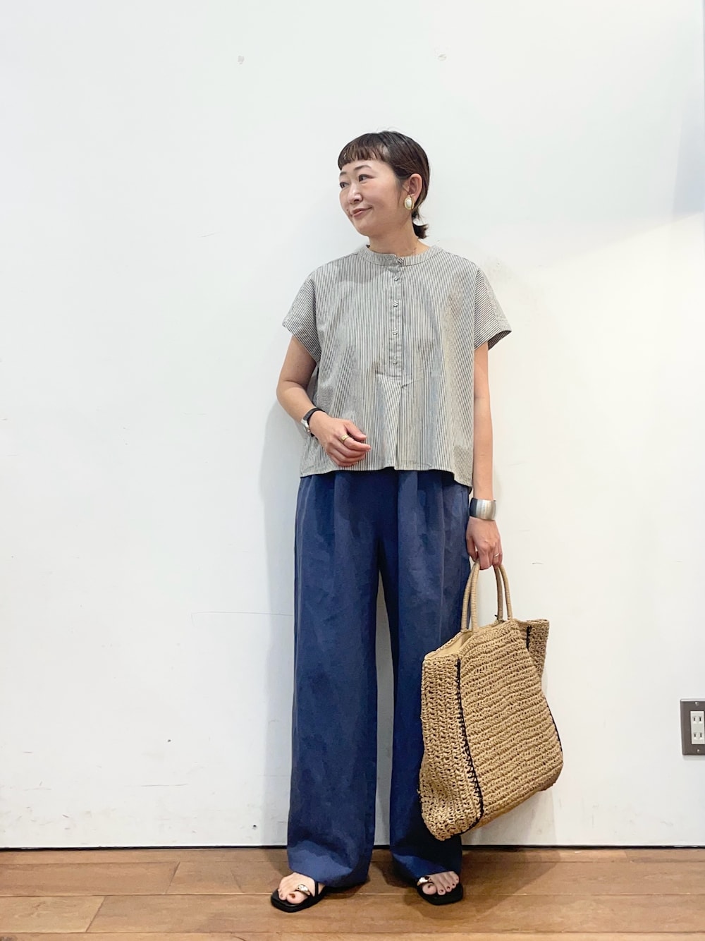 ブラック系のシャツ/ブラウス、ブルー系のその他パンツ、ベージュ系のトートバッグを着用したレディースの夏コーディネートの1枚目の写真