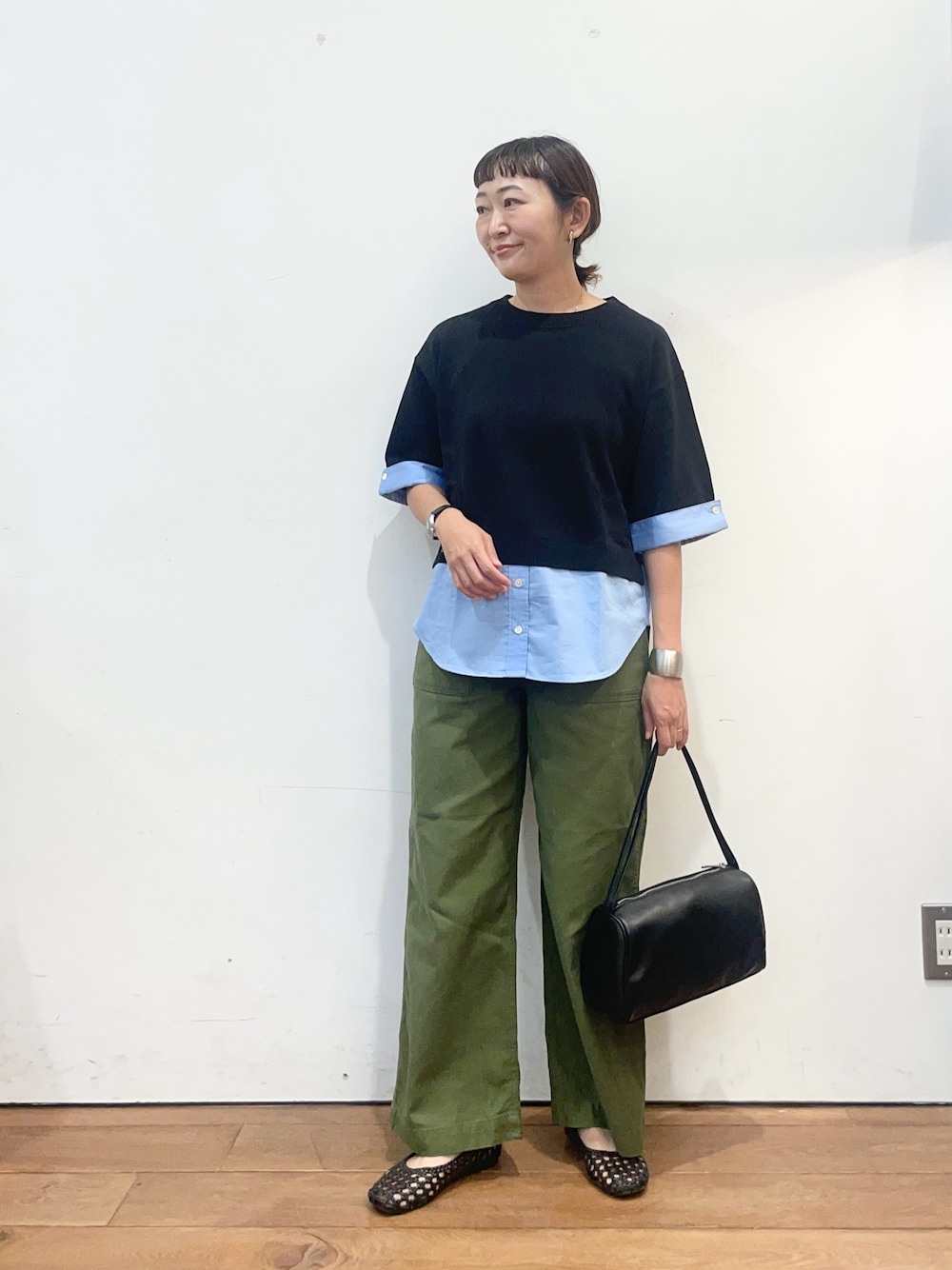 ブラック系のニット/セーター、グリーン系のその他パンツ、ブラック系のハンドバッグを着用したレディースの夏コーディネートの1枚目の写真