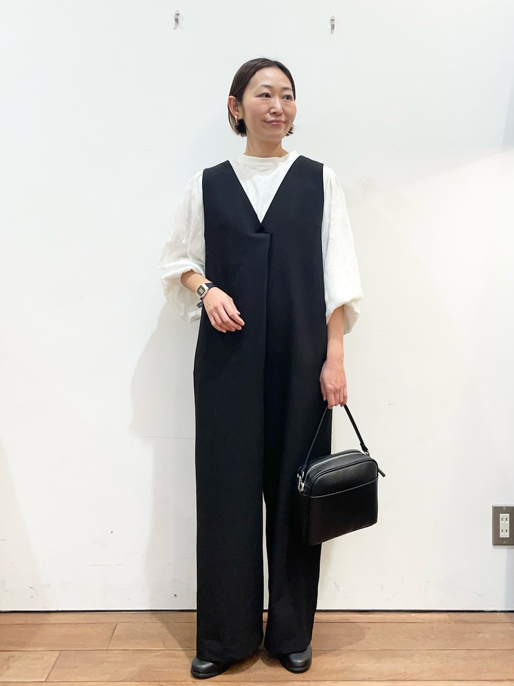 ブラック系のその他パンツ、ブラック系のショルダーバッグ、ブラック系のブーツを着用したレディースの冬コーディネートの1枚目の写真