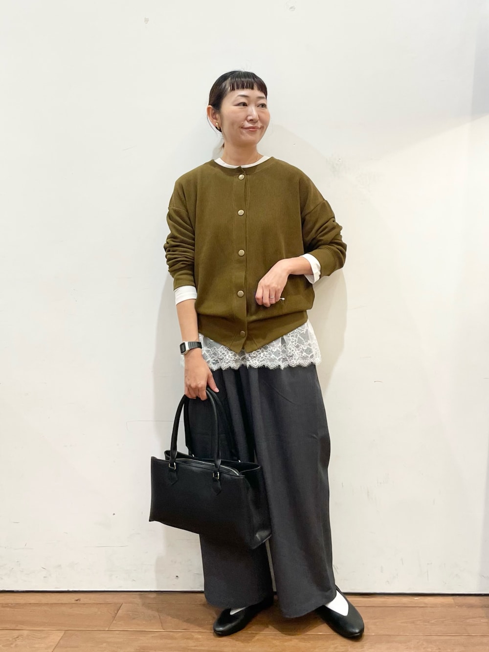 ブラウン系のカーディガン/ボレロ、ホワイト系のTシャツ/カットソー、ブラック系のハンドバッグを着用したレディースの秋コーディネートの1枚目の写真
