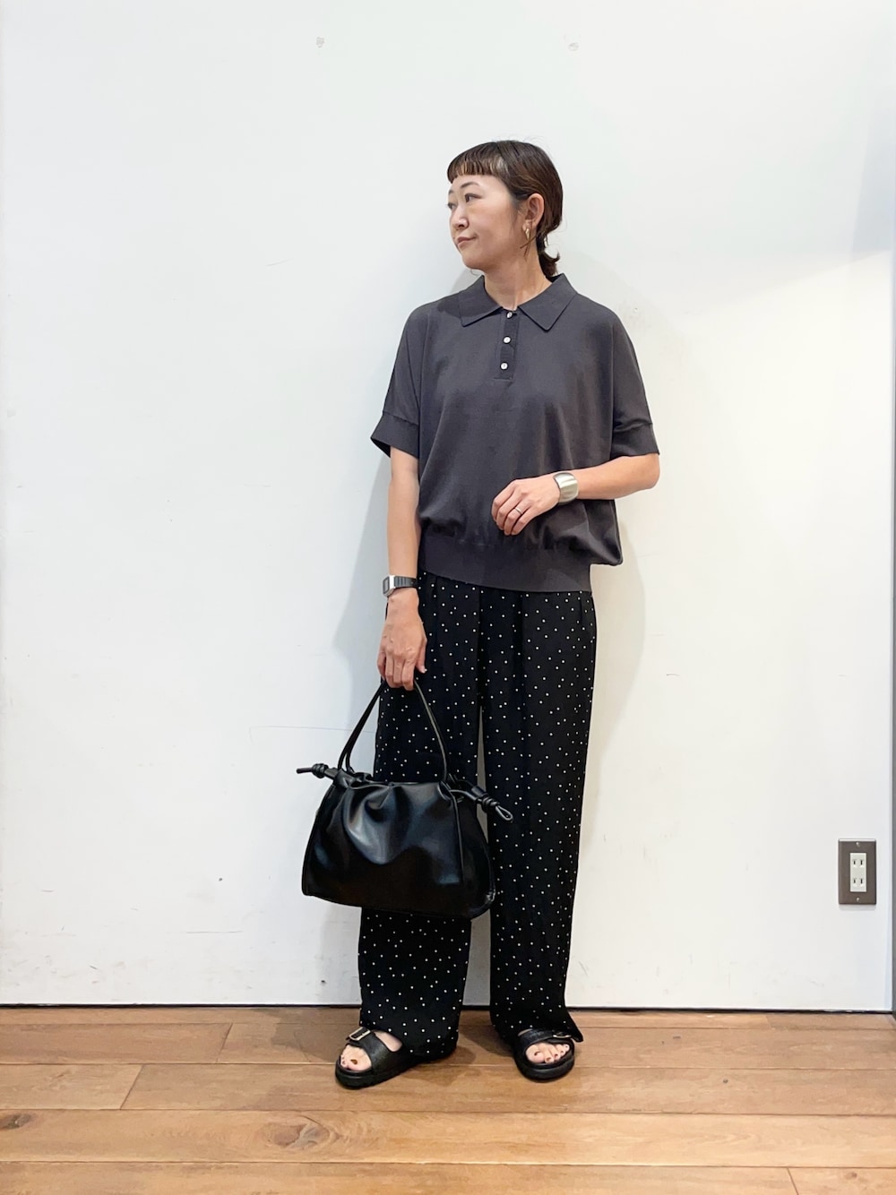 グレー系のニット/セーター、ブラック系のトートバッグ、ブラック系のサンダルを着用したレディースの夏コーディネートの1枚目の写真
