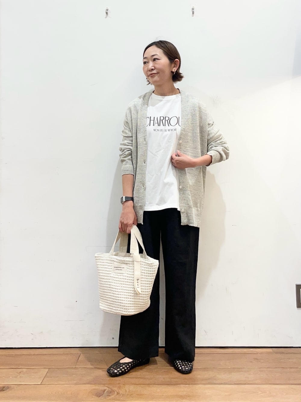 ホワイト系のTシャツ/カットソー、グレー系のカーディガン/ボレロ、ブラック系のサンダルを着用したレディースの春コーディネートの1枚目の写真