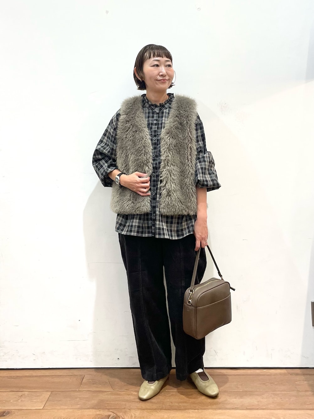 グレー系のダウンベスト、ブラック系のシャツ/ブラウス、グレー系のその他パンツを着用したレディースの秋コーディネートの1枚目の写真