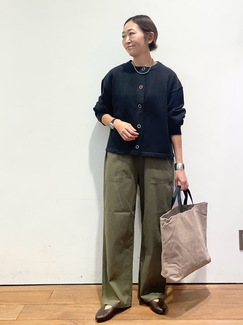 ブラック系のカーディガン/ボレロ、ブラウン系のパンプス、グレー系のバッグを着用したレディースの秋コーディネートの1枚目の写真