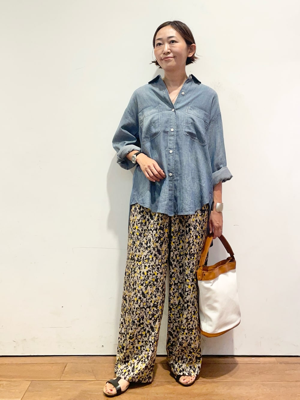 ベージュ系のその他パンツ、ブラック系のサンダル、ブルー系のシャツ/ブラウスを着用したレディースの夏コーディネートの1枚目の写真