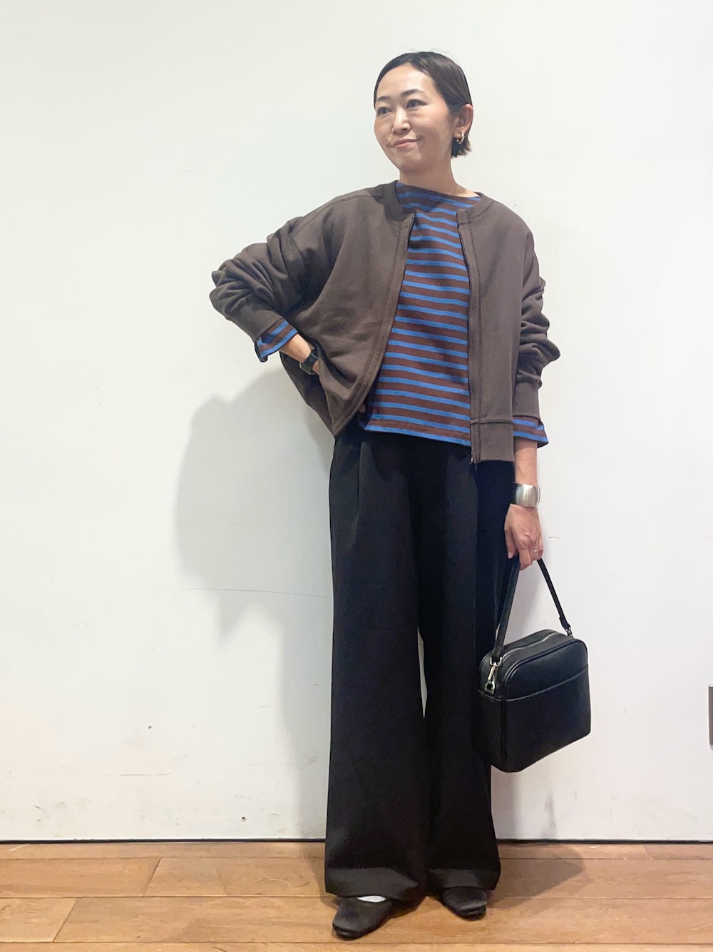 ブラウン系のカーディガン/ボレロ、ブラウン系のTシャツ/カットソー、ブラック系のその他パンツを着用したレディースの秋コーディネートの1枚目の写真