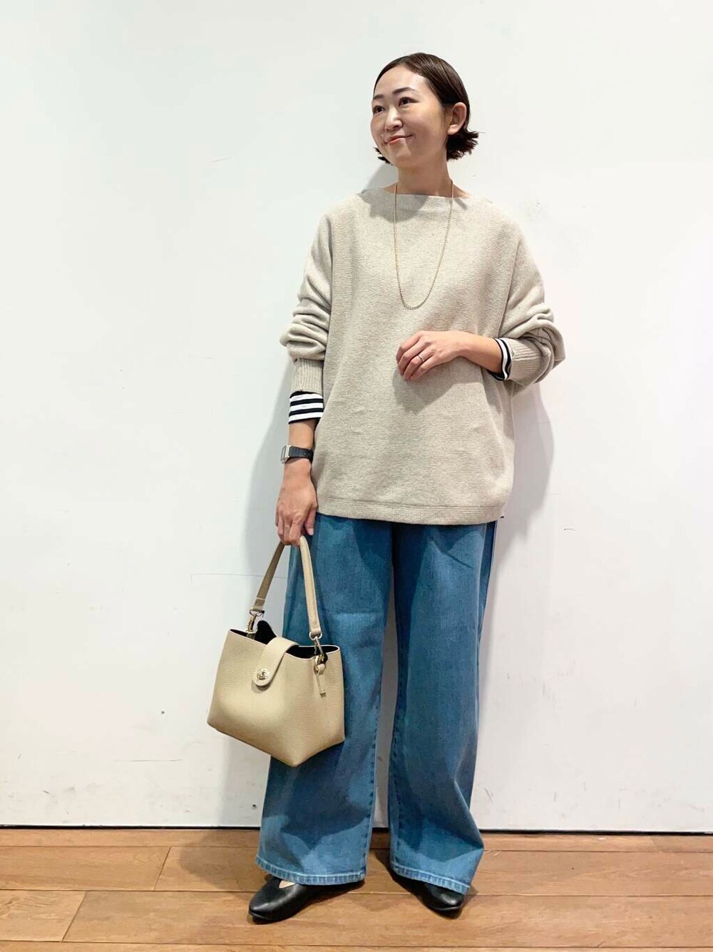 ブラック系のパンプス、ベージュ系のニット/セーター、ベージュ系のショルダーバッグを着用したレディースの秋コーディネートの1枚目の写真