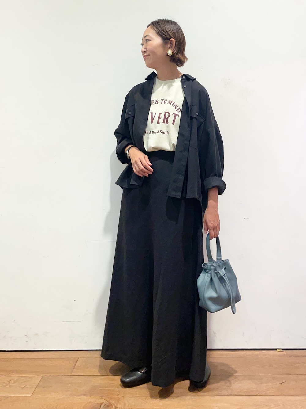 ベージュ系のTシャツ/カットソー、ブラック系のシャツ/ブラウス、ブラック系のスカートを着用したレディースの秋コーディネートの1枚目の写真