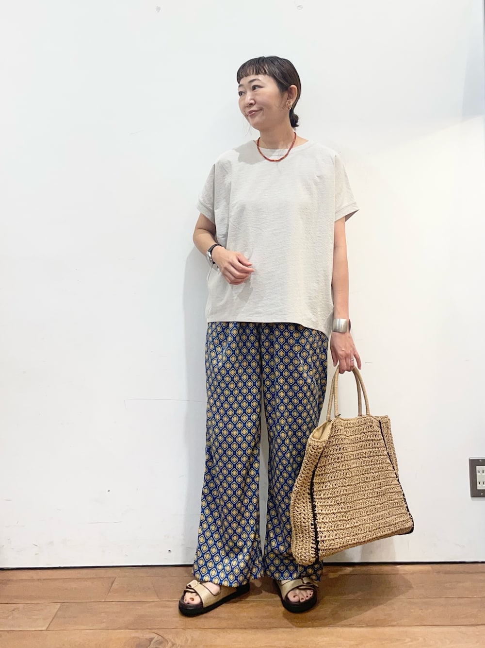 グレー系のTシャツ/カットソー、ブルー系のその他パンツ、ベージュ系のトートバッグを着用したレディースの夏コーディネートの1枚目の写真