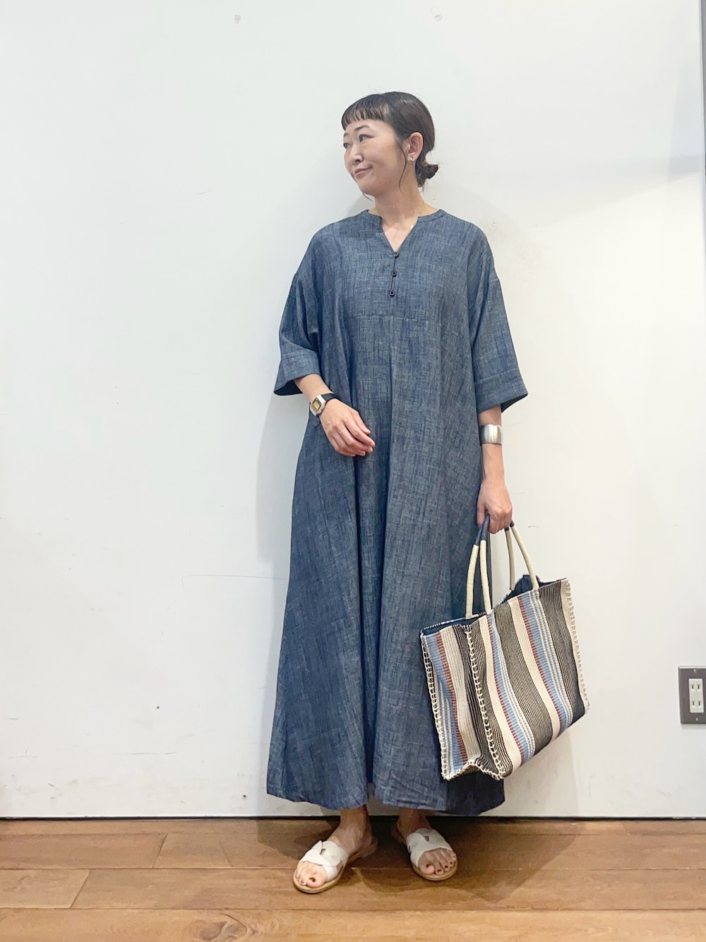 ブルー系のワンピース、ブルー系のトートバッグ、ホワイト系のサンダルを着用したレディースの夏コーディネートの1枚目の写真
