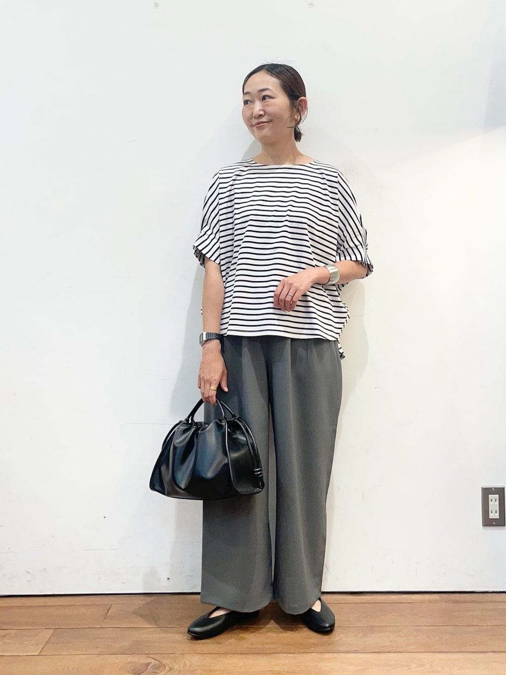 ホワイト系のTシャツ/カットソー、ブラック系のパンプス、ブラック系のトートバッグを着用したレディースの春コーディネートの1枚目の写真