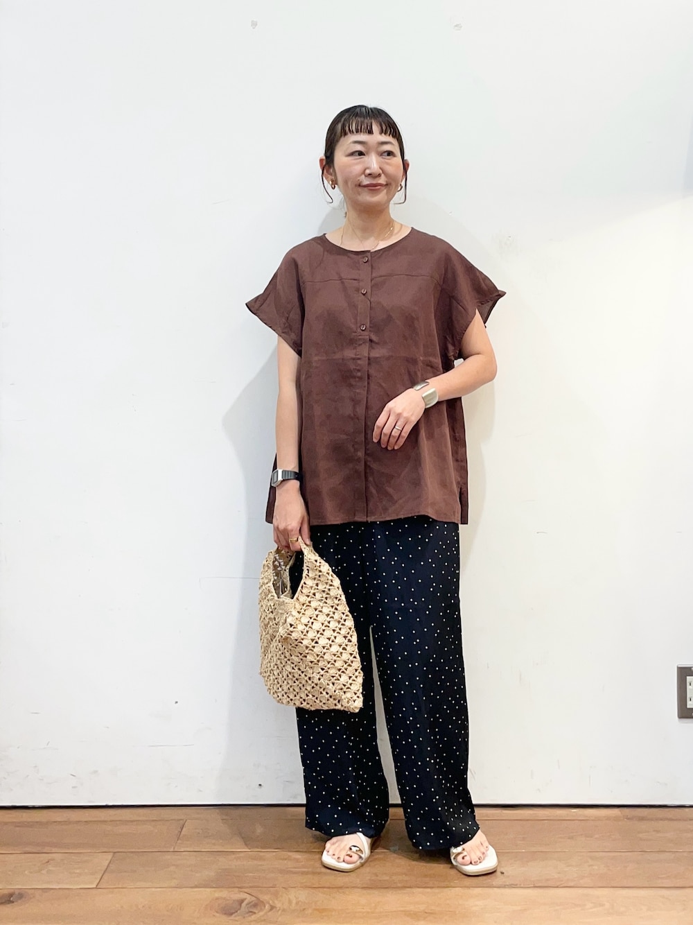 ブラウン系のシャツ/ブラウス、ブルー系のその他パンツ、ベージュ系のハンドバッグを着用したレディースの夏コーディネートの1枚目の写真