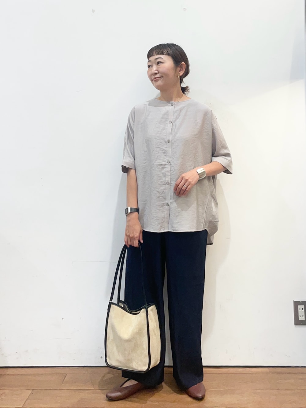 グレー系のシャツ/ブラウス、ブラウン系のパンプス、ベージュ系のトートバッグを着用したレディースの夏コーディネートの1枚目の写真