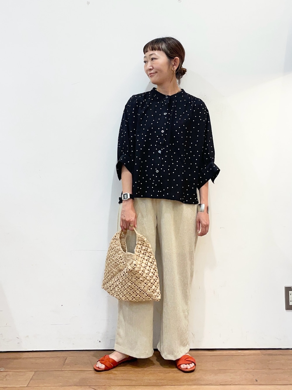 ブラック系のシャツ/ブラウス、ベージュ系のハンドバッグ、ベージュ系のその他パンツを着用したレディースの夏コーディネートの1枚目の写真