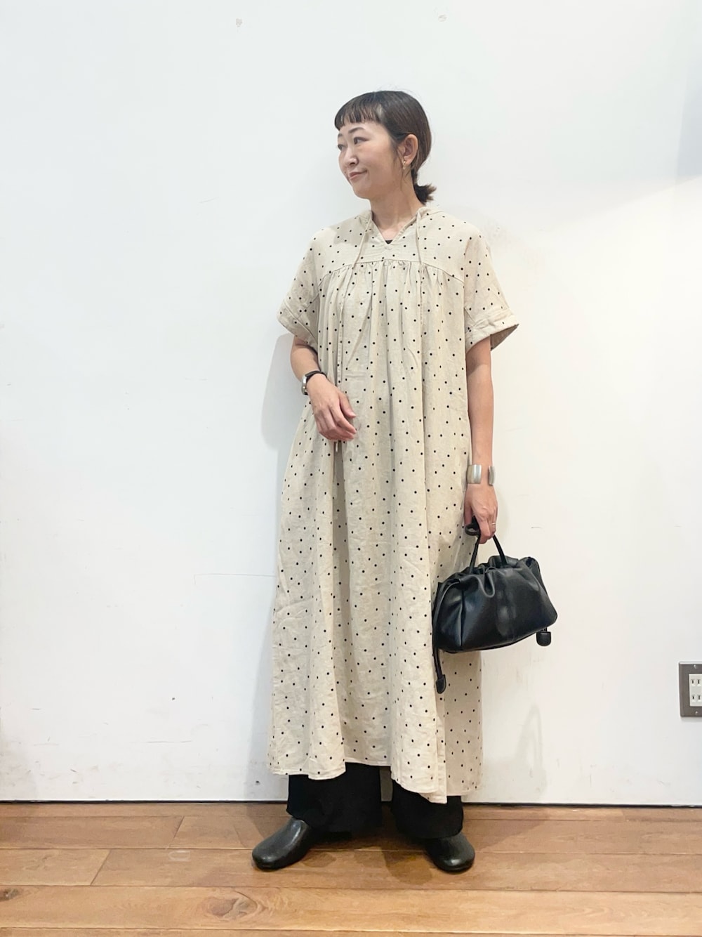 ベージュ系のワンピース、ブラック系のショルダーバッグ、ブラック系のその他シューズを着用したレディースの夏コーディネートの1枚目の写真
