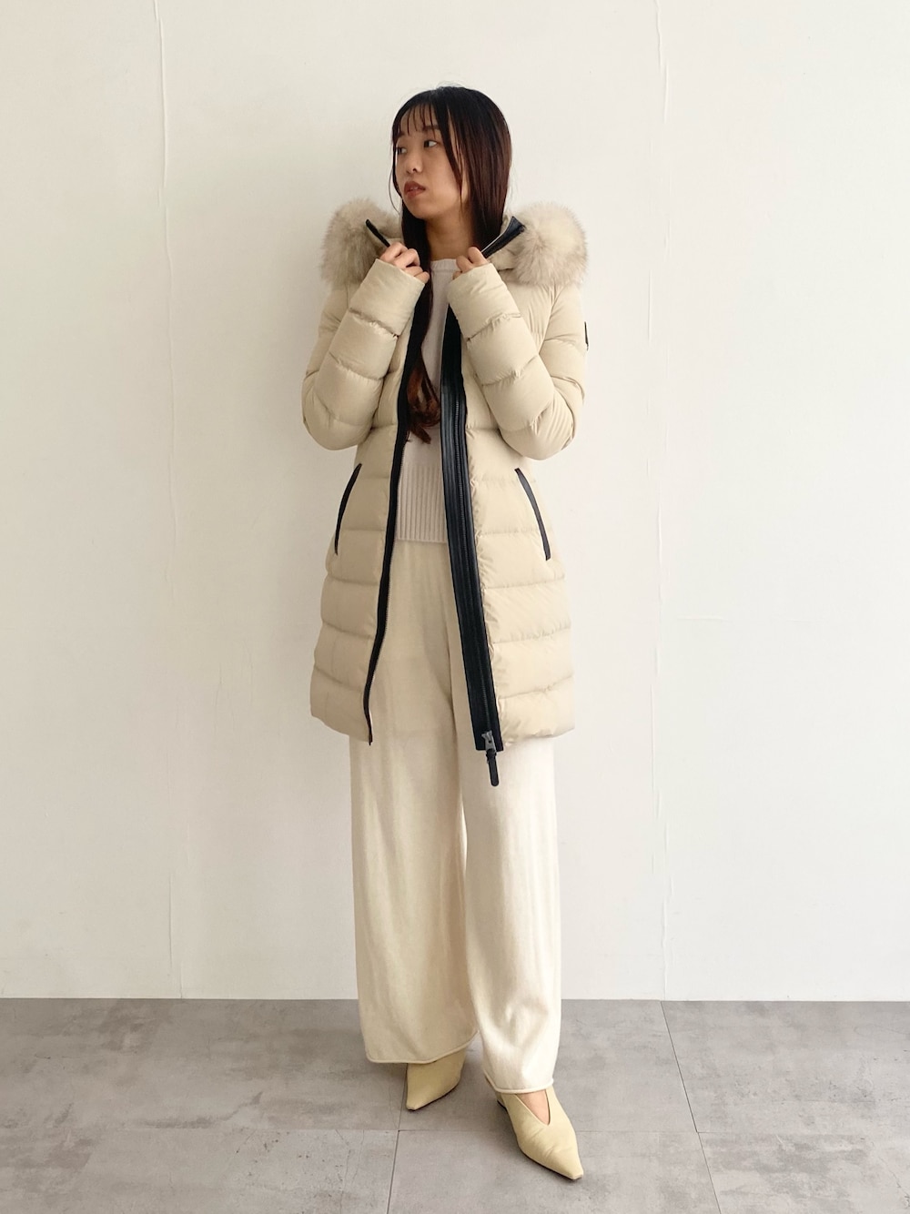 ベージュ系のその他アウター、ホワイト系のニット/セーター、ホワイト系のその他パンツを着用したレディースの秋コーディネートの1枚目の写真