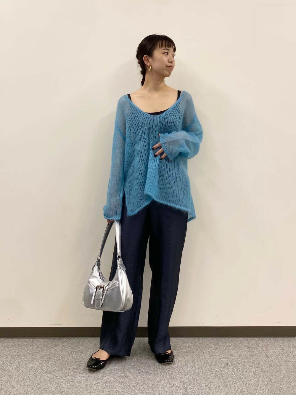ブルー系のニット/セーター、グレー系のその他パンツ、シルバー系のハンドバッグを着用したレディースの夏コーディネートの1枚目の写真