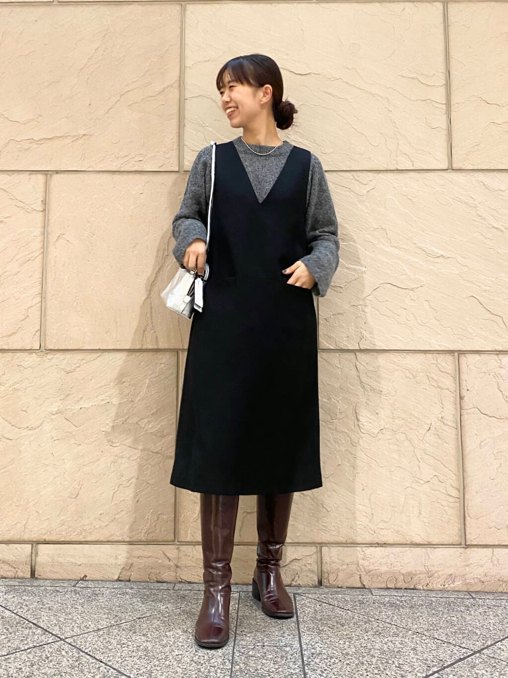 レッド系のブーツ、ブラック系のワンピース、グレー系のニット/セーターを着用したレディースの冬コーディネートの1枚目の写真