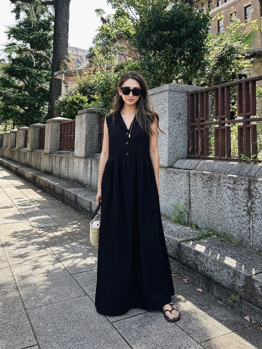 ブラック系のワンピースを着用したレディースの夏コーディネートの1枚目の写真