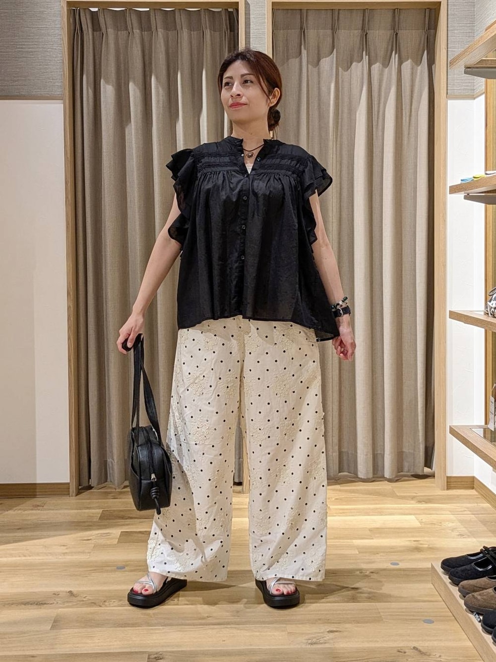 ブラック系のシャツ/ブラウス、ブラック系のショルダーバッグ、ホワイト系のその他パンツを着用したレディースの夏コーディネートの1枚目の写真