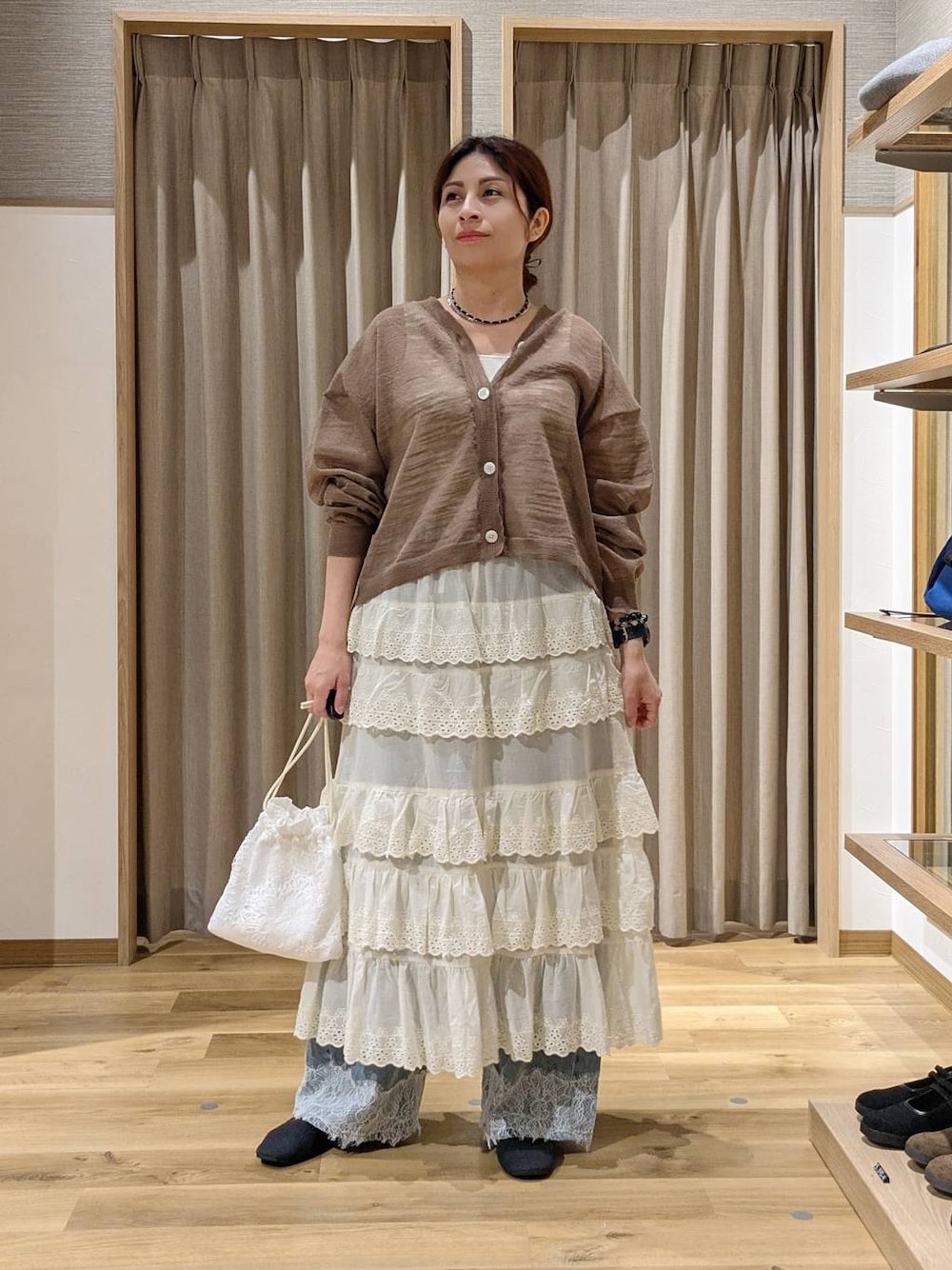 ブルー系のデニムパンツ、ホワイト系のスカート、ホワイト系のタンクトップを着用したレディースの夏コーディネートの1枚目の写真