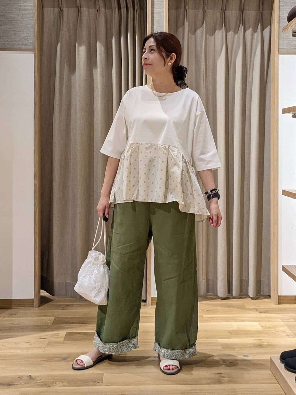グリーン系のデニムパンツ、ベージュ系のTシャツ/カットソー、ベージュ系のサンダルを着用したレディースの夏コーディネートの1枚目の写真
