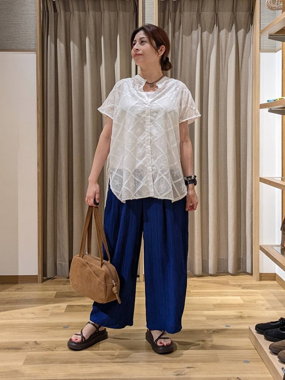 ブラウン系のショルダーバッグ、ブルー系のその他パンツ、ブラウン系のサンダルを着用したレディースの夏コーディネートの1枚目の写真