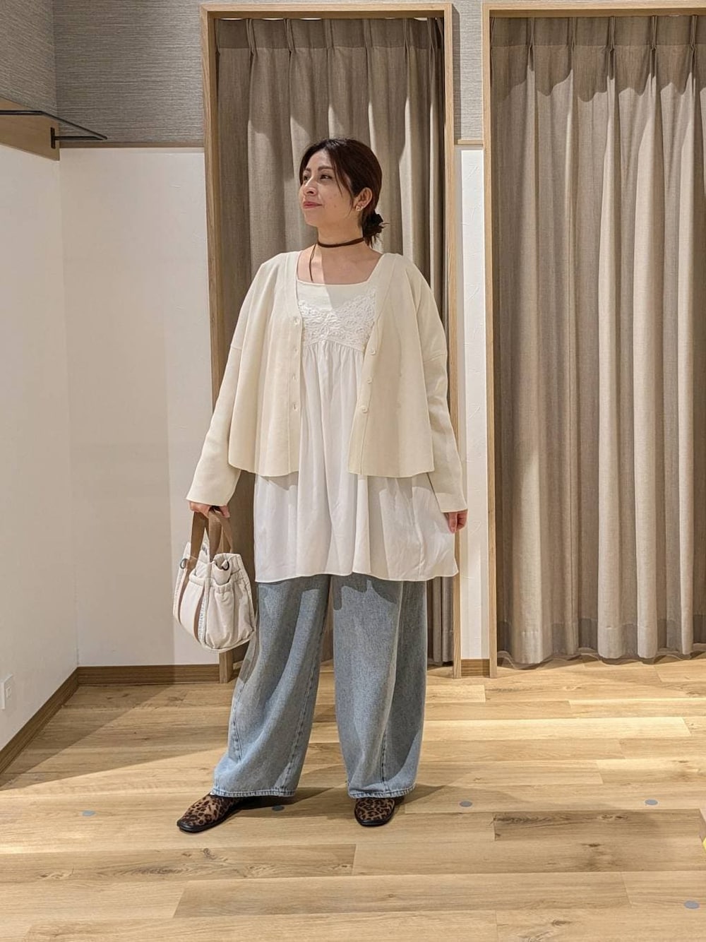 ブルー系のデニムパンツ、ブラウン系のパンプス、ベージュ系のタンクトップを着用したレディースの春コーディネートの1枚目の写真