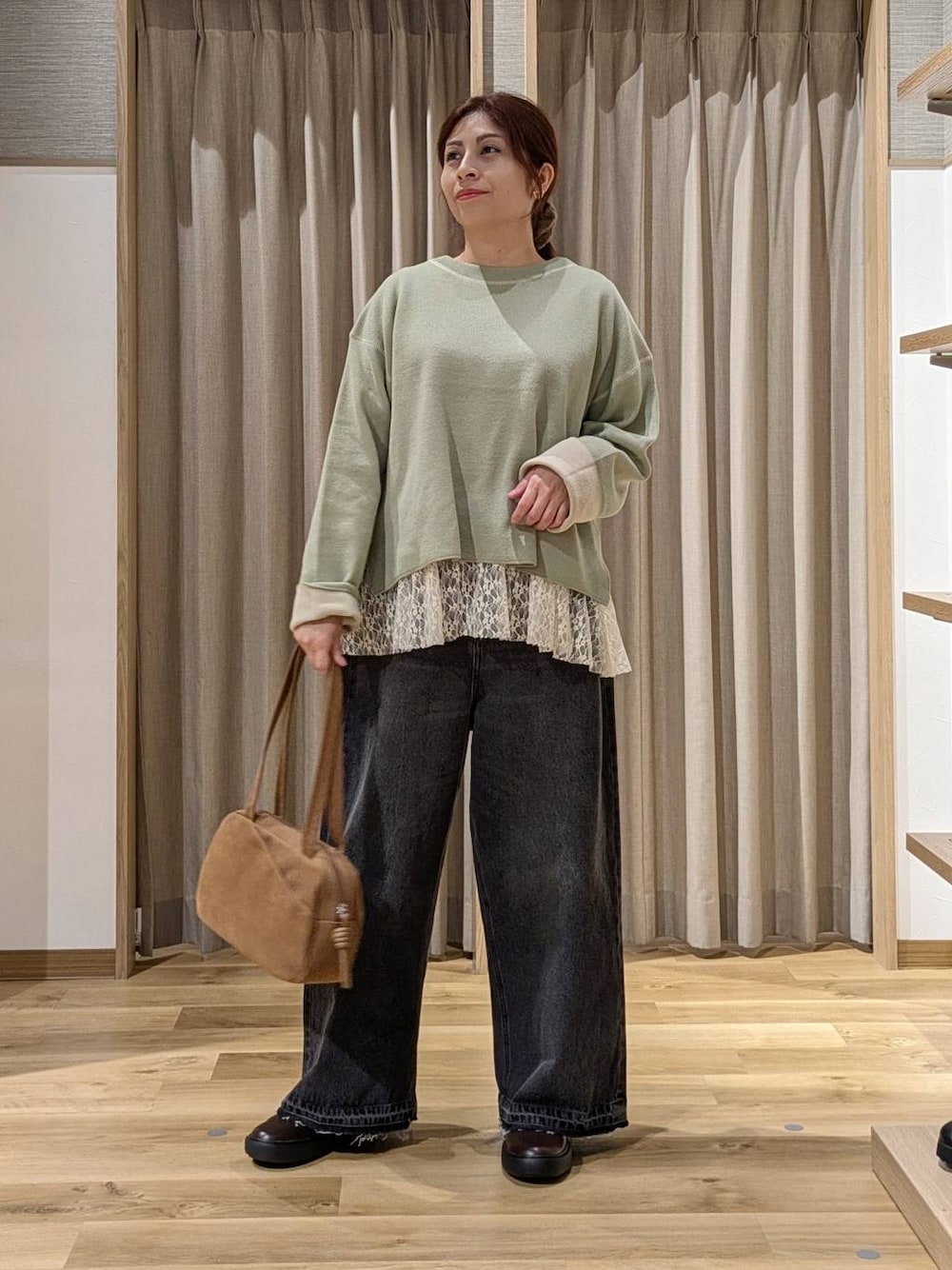 ブラウン系のショルダーバッグ、その他のTシャツ/カットソー、グリーン系のニット/セーターを着用したレディースの秋コーディネートの1枚目の写真
