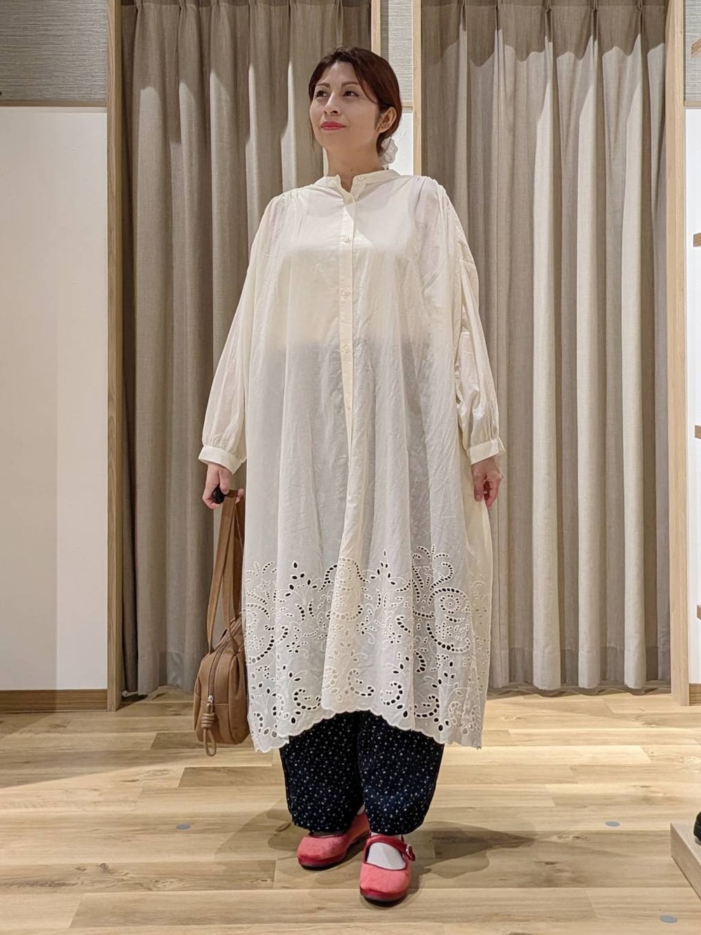 ブラウン系のショルダーバッグ、ブルー系のその他パンツ、レッド系のその他シューズを着用したレディースの秋コーディネートの1枚目の写真