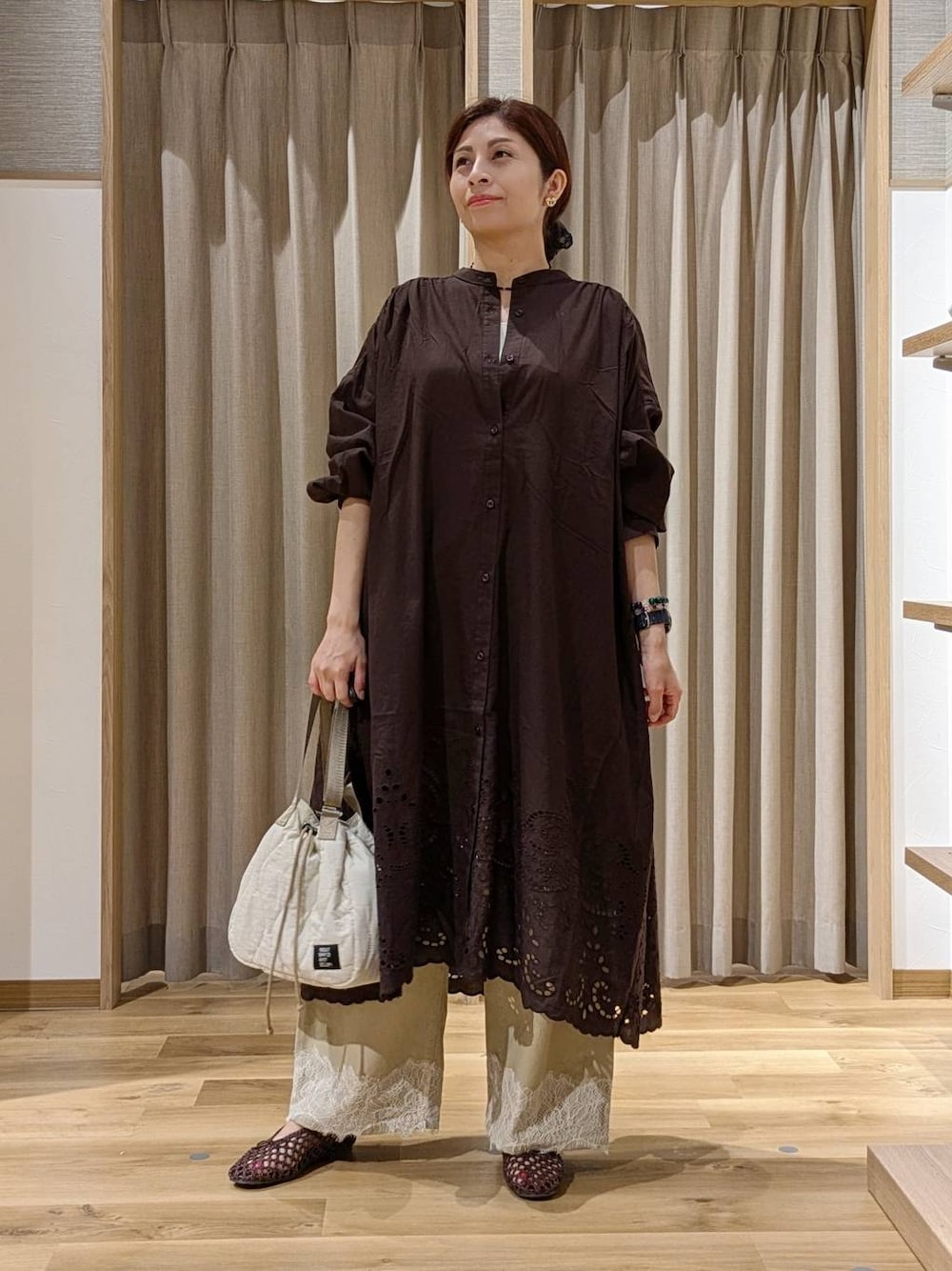 ベージュ系のデニムパンツ、ブラウン系のワンピース、ブラウン系のパンプスを着用したレディースの秋コーディネートの1枚目の写真