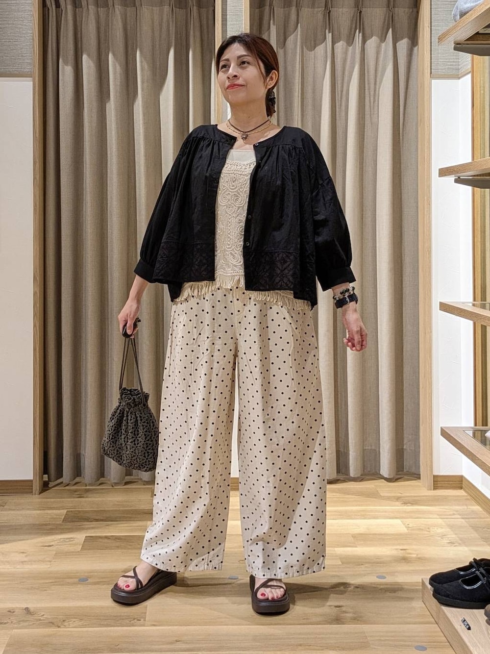 ベージュ系のシャツ/ブラウス、ブラック系のシャツ/ブラウス、ブラウン系のサンダルを着用したレディースの夏コーディネートの1枚目の写真