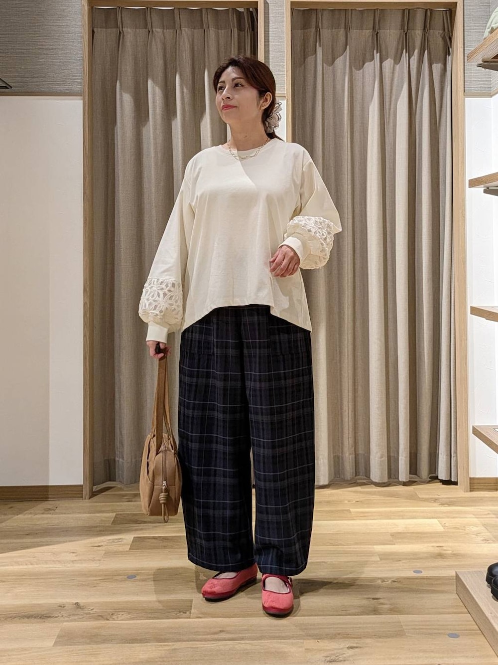 ブラウン系のショルダーバッグ、レッド系のその他シューズ、ホワイト系のTシャツ/カットソーを着用したレディースの秋コーディネートの1枚目の写真