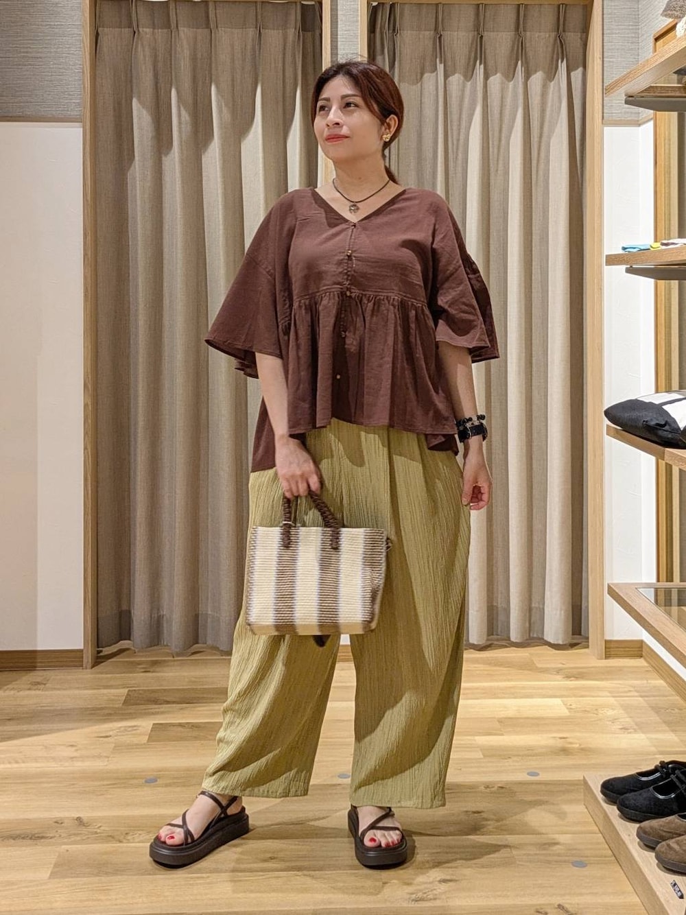 イエロー系のその他パンツ、ブルー系のショルダーバッグ、ブラウン系のサンダルを着用したレディースの夏コーディネートの1枚目の写真