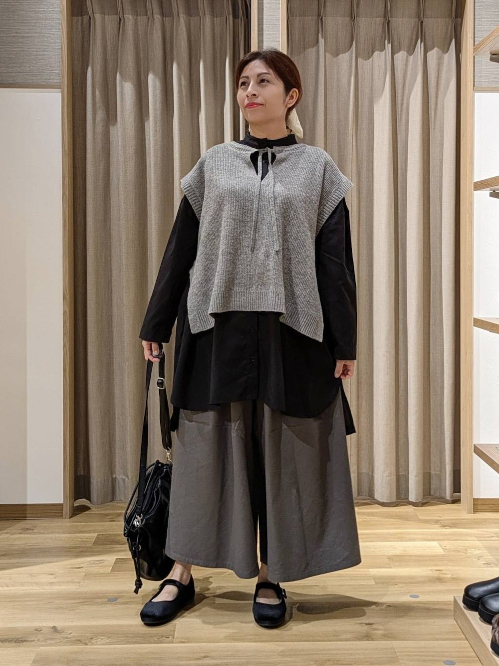 グレー系のチノパンツ、ブラック系のその他シューズ、ブラック系のショルダーバッグを着用したレディースの秋コーディネートの1枚目の写真