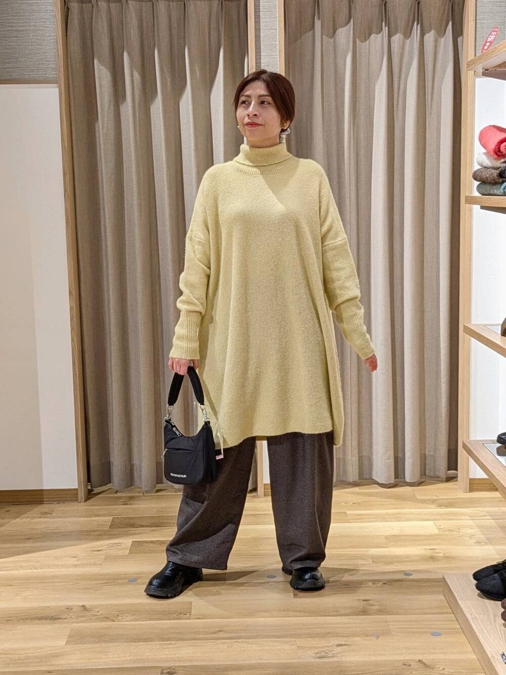 ブラック系のブーツ、ブラウン系のその他パンツ、ブラック系のショルダーバッグを着用したレディースの冬コーディネートの1枚目の写真