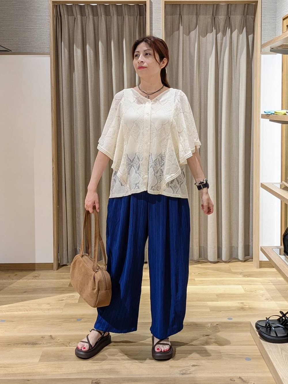ブラウン系のショルダーバッグ、ベージュ系のシャツ/ブラウス、ブルー系のその他パンツを着用したレディースの夏コーディネートの1枚目の写真