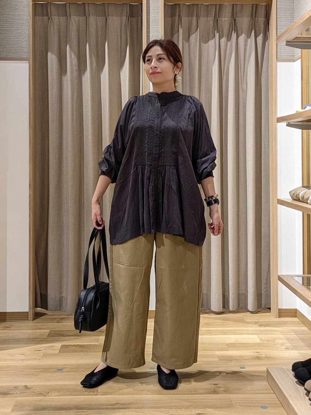 ブラック系のショルダーバッグ、その他のシャツ/ブラウス、ブラック系のパンプスを着用したレディースの秋コーディネートの1枚目の写真