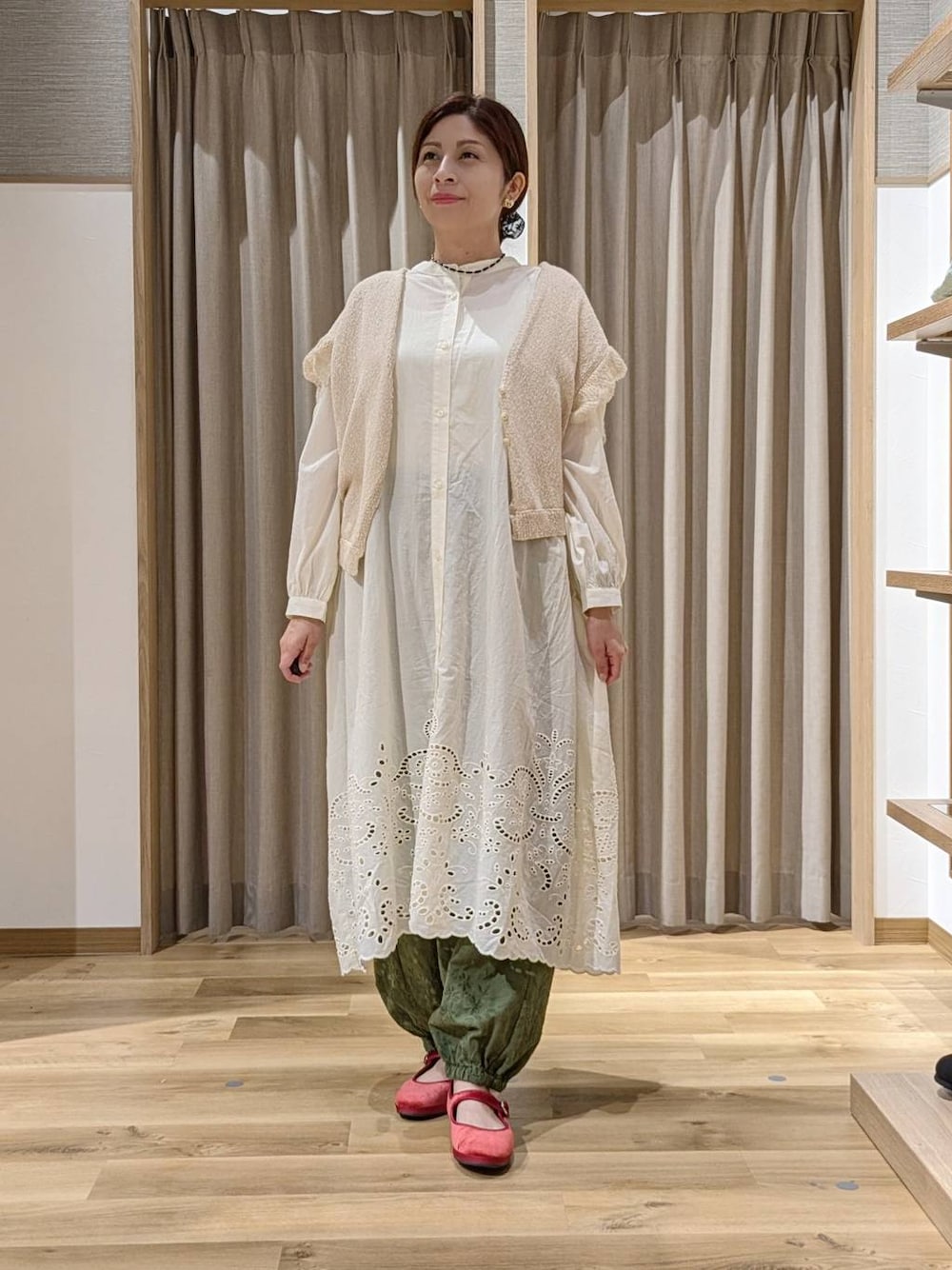 グリーン系のその他パンツ、レッド系のその他シューズ、ベージュ系のニット/セーターを着用したレディースの秋コーディネートの1枚目の写真