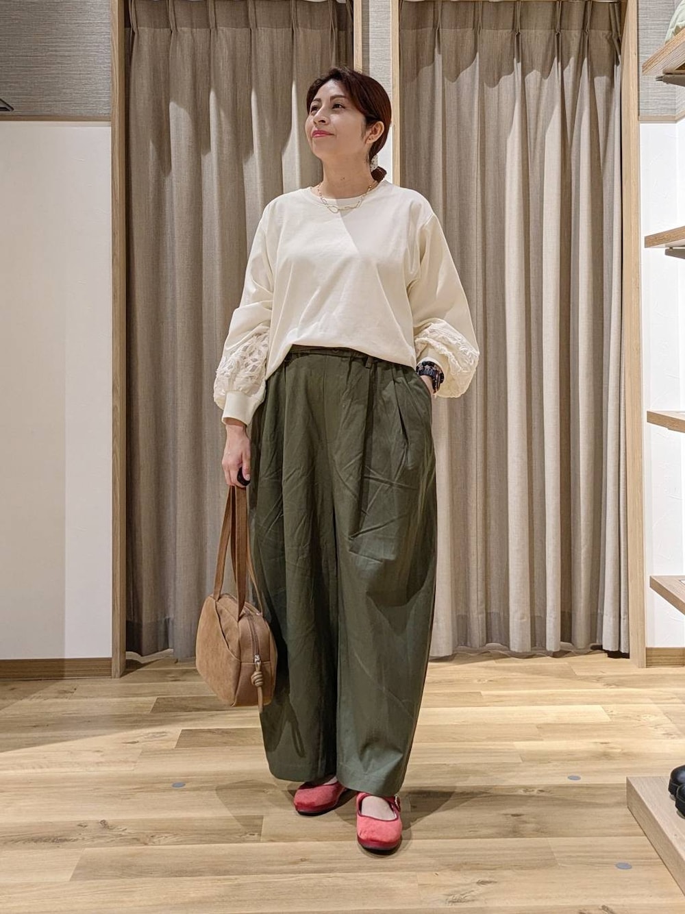 ブラウン系のショルダーバッグ、レッド系のその他シューズ、ホワイト系のTシャツ/カットソーを着用したレディースの秋コーディネートの1枚目の写真
