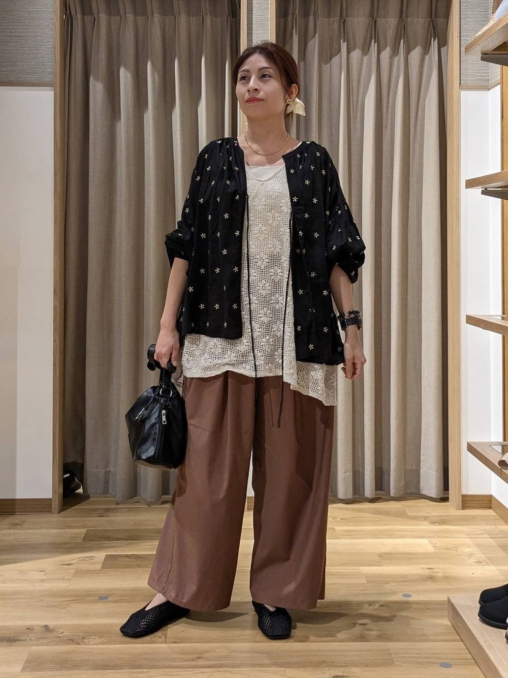 ブラック系のシャツ/ブラウス、ホワイト系のベスト、ブラック系のトートバッグを着用したレディースの夏コーディネートの1枚目の写真