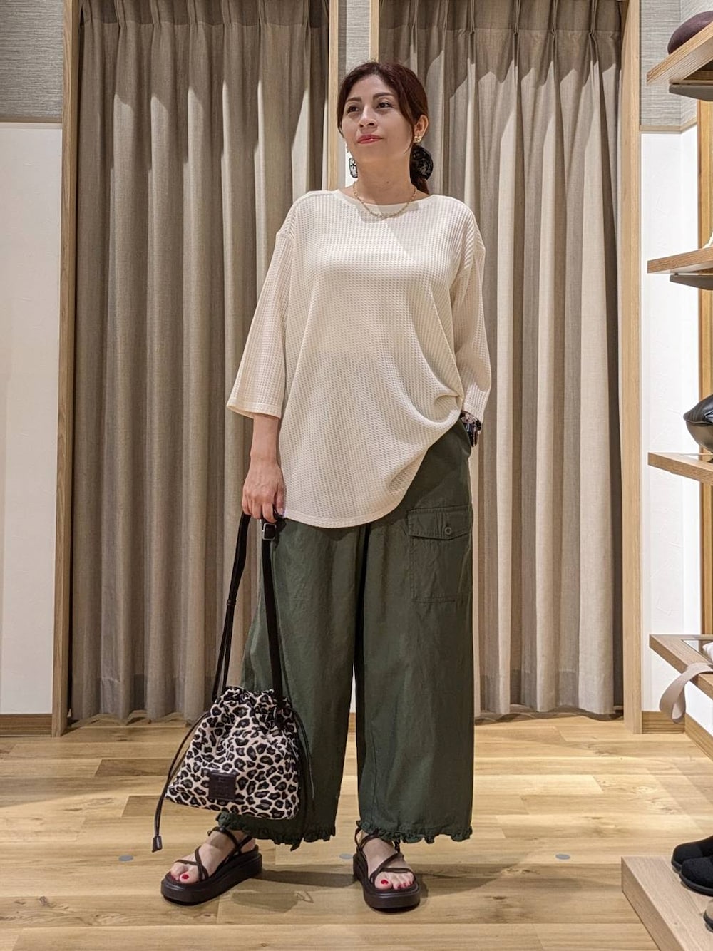グリーン系のその他パンツ、ベージュ系のTシャツ/カットソー、ブラウン系のサンダルを着用したレディースの夏コーディネートの1枚目の写真