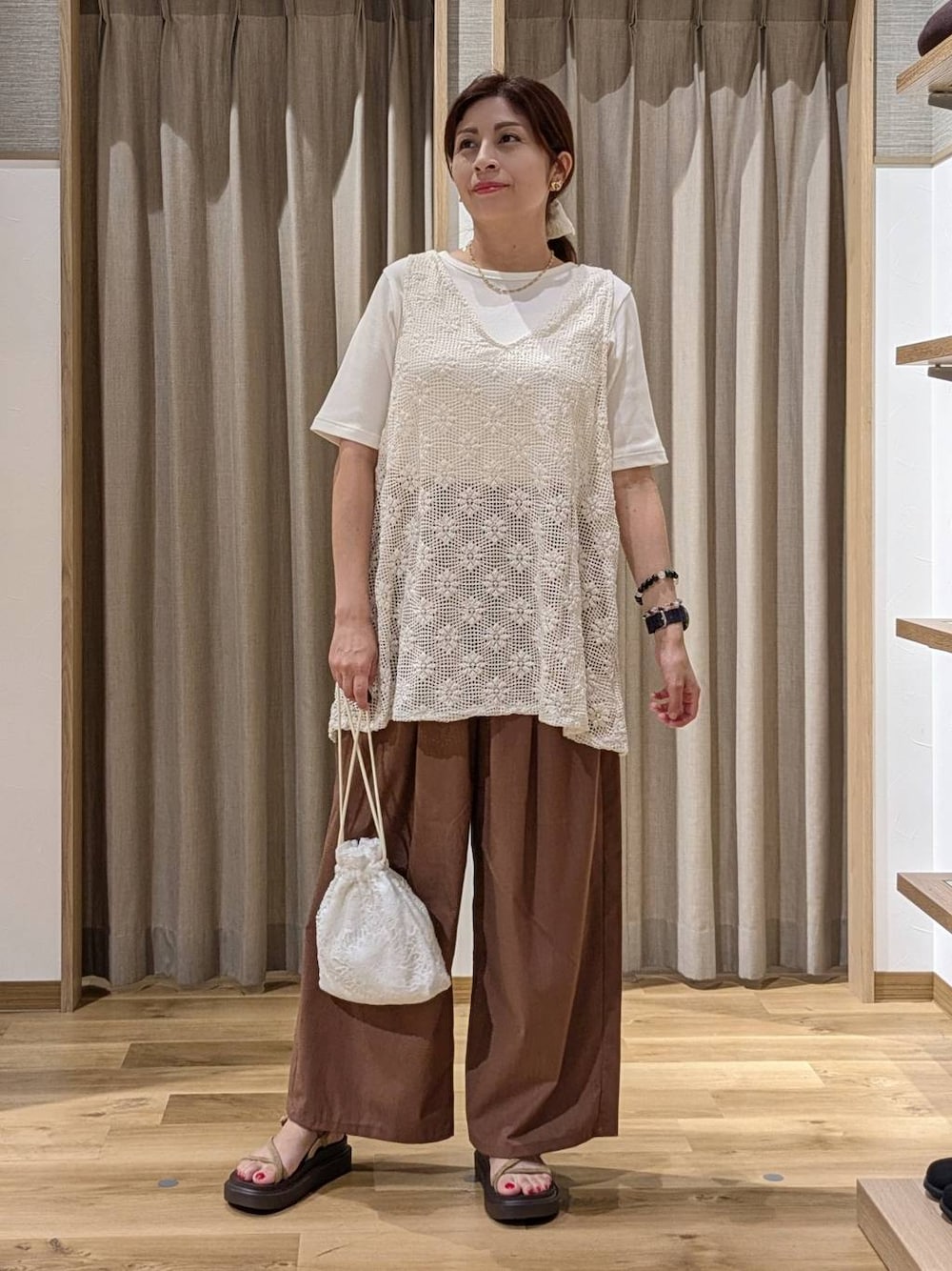 ホワイト系のTシャツ/カットソー、ベージュ系のサンダル、ホワイト系のベストを着用したレディースの夏コーディネートの1枚目の写真