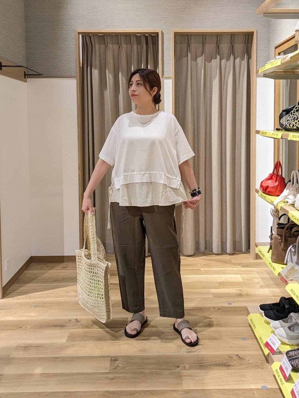 ベージュ系のトートバッグ、ベージュ系のサンダル、ホワイト系のTシャツ/カットソーを着用したレディースの夏コーディネートの1枚目の写真